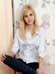 Petite blonde beauty Violeta smiles sweetly in her white blouse and black pants