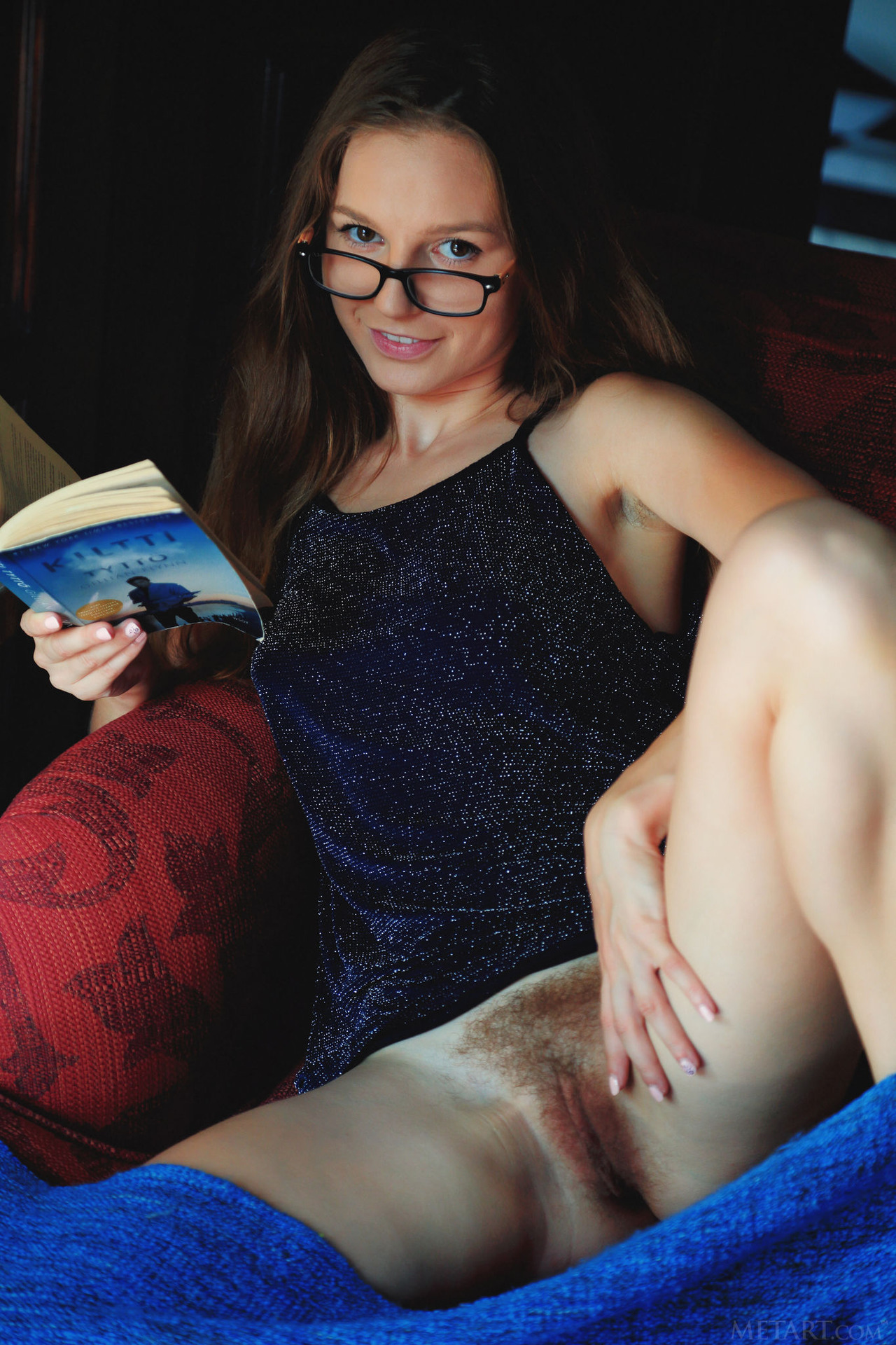 Cute Sofi Shane sits in an armchair reading 02